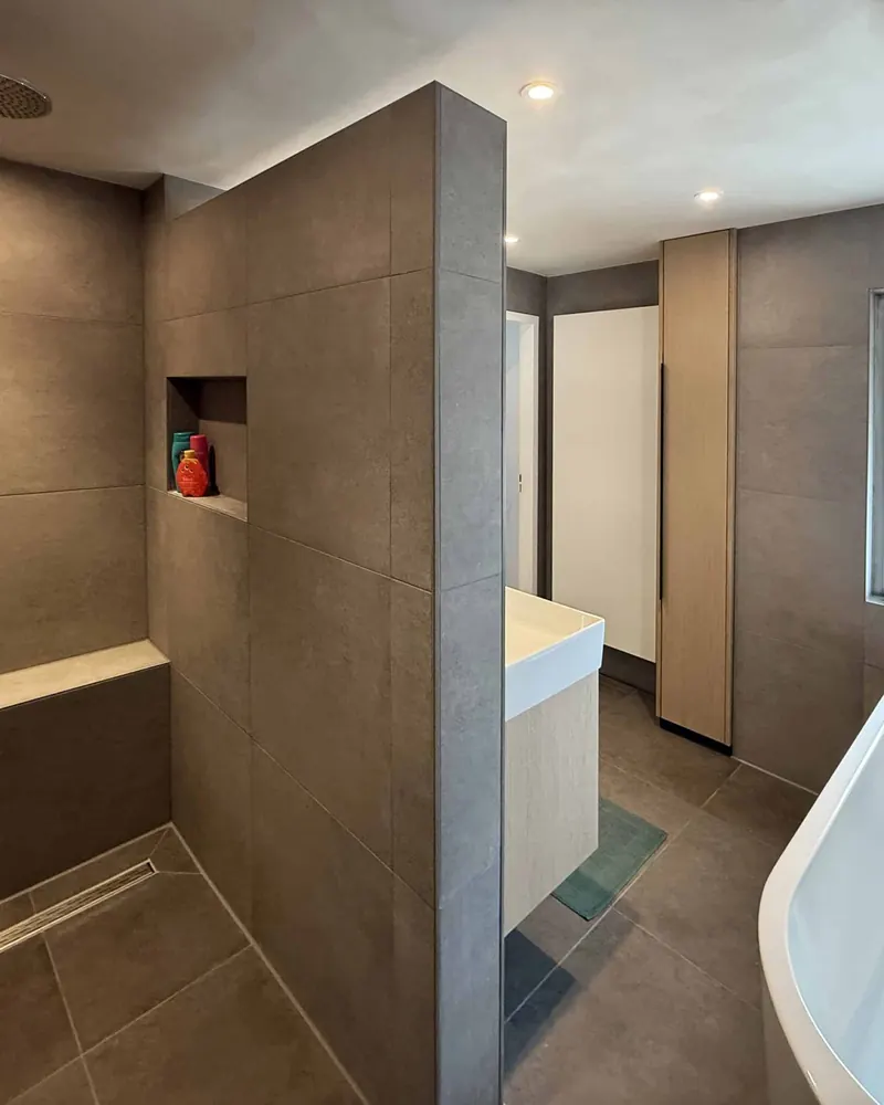 Inloopdouche met betonlook tegels en een nis in de wand